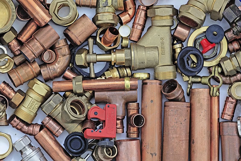 Top 5 Plumbing Upgrades to Include in Your Kitchen Remodel. Photo of water pipes and tools laid out on a surface.